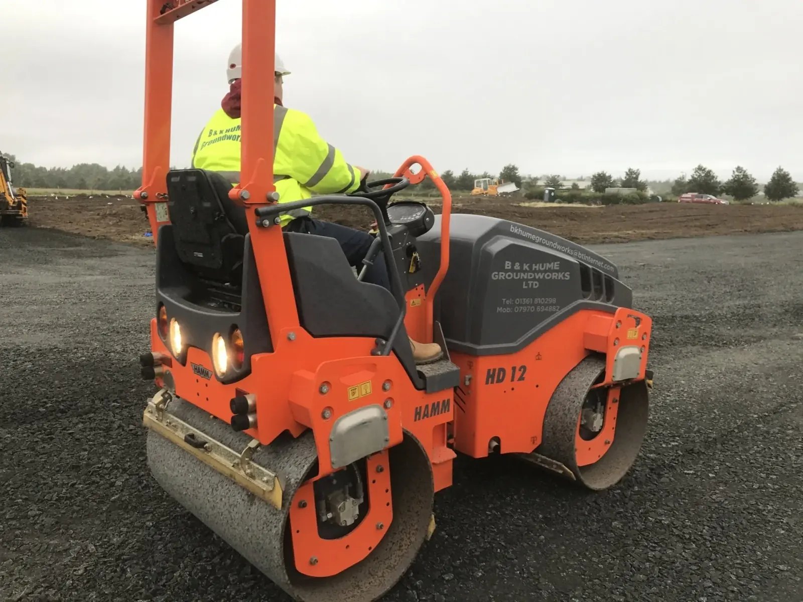 B&K Hume operator compacting fresh tarmac with a Hamm HD12 roller